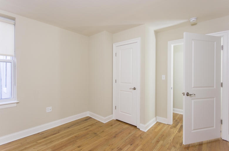 Bedroom with hardwood flooring and ample closet space