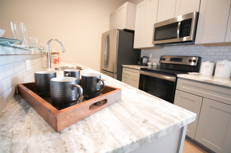 Fully equipped modern kitchen with stainless steel appliances at The Cottages at The Mills