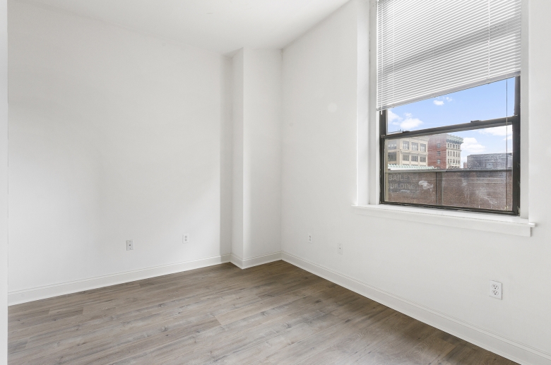 White walls contrasting hardwood floors at 1300 Chestnut Street