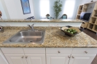 Breakfast bar features granite counter top and stainless steel under-mounted sinks