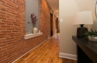 Hallway featuring brick wall and recessed lighting